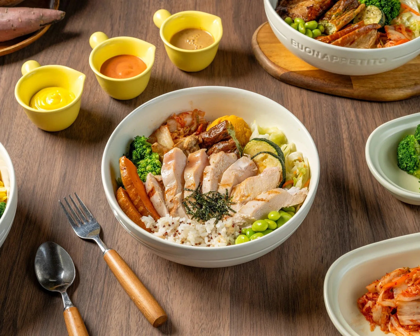 炙烤舒肥嫩雞胸餐碗，搭配毛豆、花椰菜、泡菜與五穀飯，放在木桌上